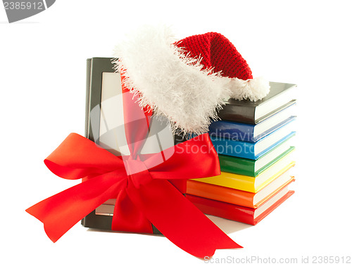 Image of Electronic book reader wearing Santa's hat with stack of books