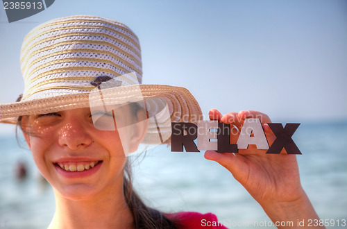 Image of Teen girl at a beach holding word 'Relax'