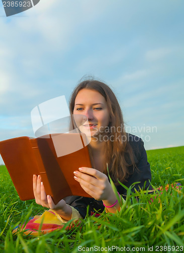 Image of Teen girl reading the Bible outdoors