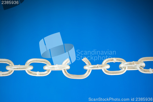 Image of Steel chain with a broken link over blue background