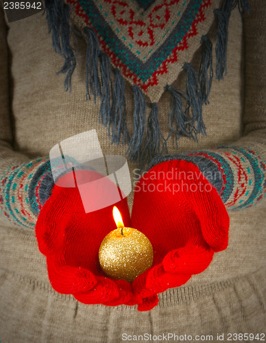 Image of Human hands hold burning  golden candle