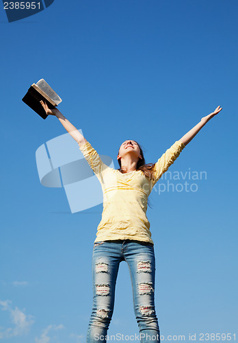 Image of Young woman staying with raised hands