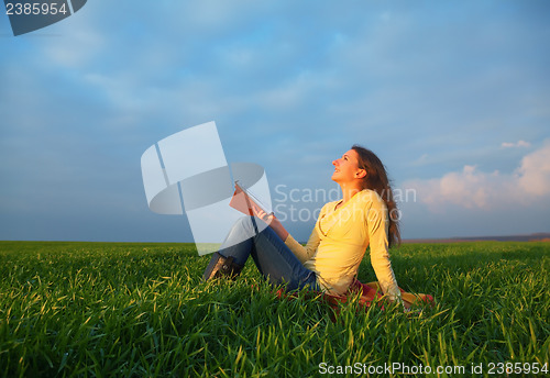 Image of Teen girl reading the Bible outdoors