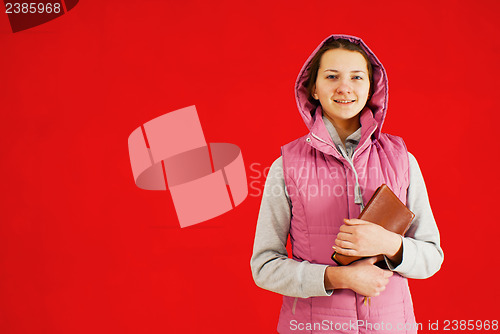 Image of Teen girl staying with a book