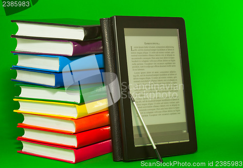 Image of E-book reader with stack of printed books