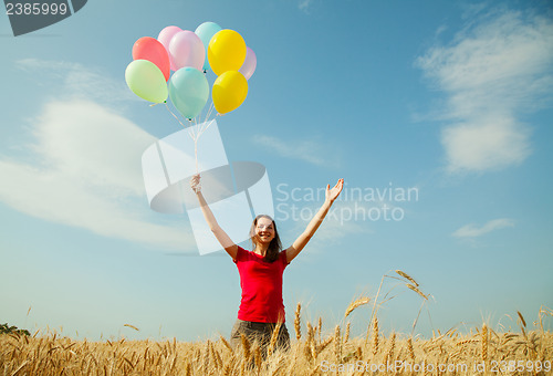Image of Teen girl at a wheat field with colorful balloons