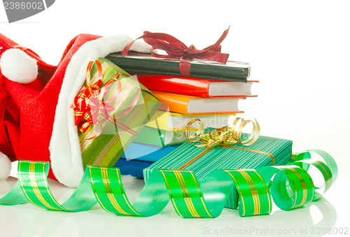Image of Christmas presents with e-book reader and books in bag against white background