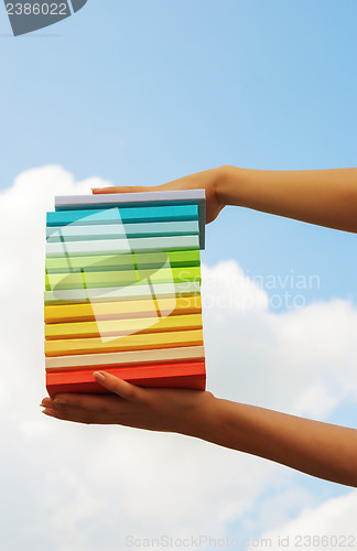 Image of Hands holding colorful hard cover books