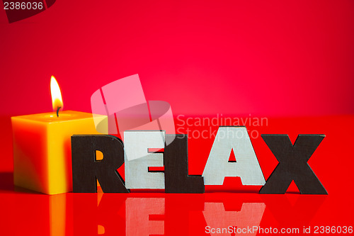 Image of Wooden word 'Relax' with a burning candle