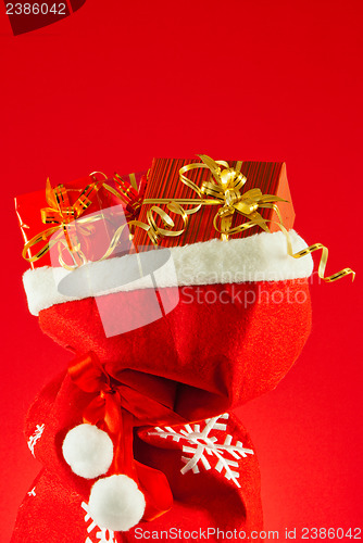 Image of Christmas presents in the bag against red background