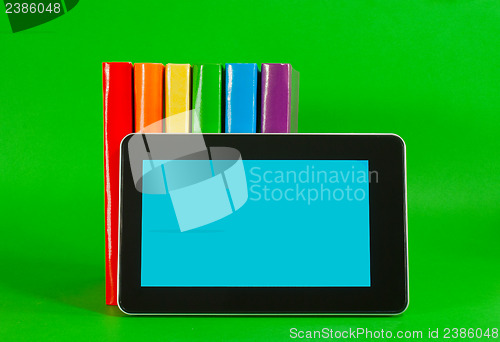 Image of Row of colorful books and tablet PC