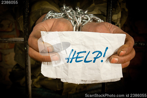 Image of Man with hands tied with chain