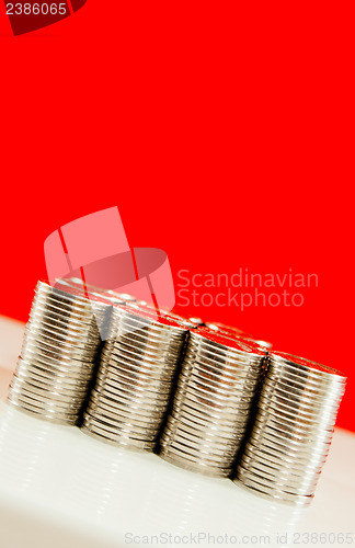 Image of Coins stacked in bars against red background