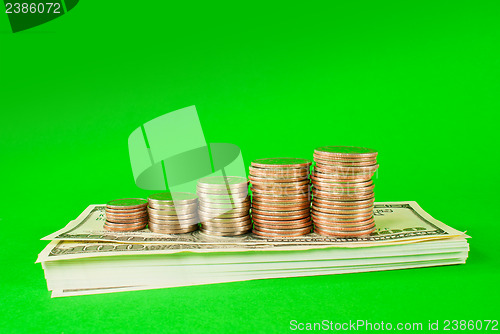 Image of Coins stacked in bars laying on stack of 100 dollar bills