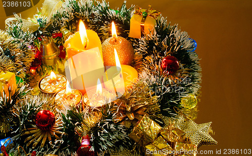 Image of Christmas garland and burning candles over golden background