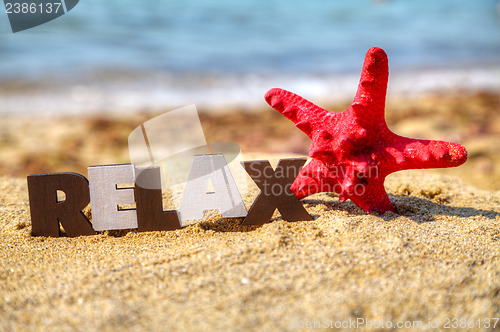 Image of Wooden word 'Relax' with red starfish