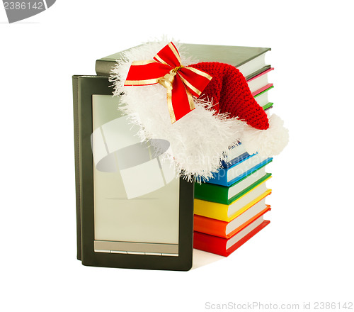 Image of Electronic book reader wearing Santa's hat with stack of books