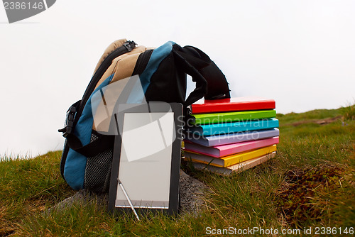 Image of Stack of colorful books and electronic book reader