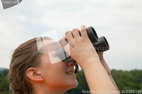 Image of Young woman looking through binoculars
