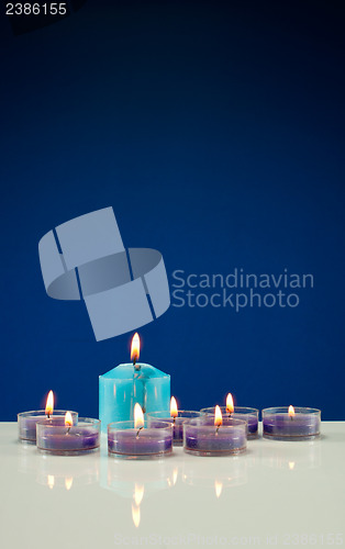 Image of A lot of burning candles against dark blue background