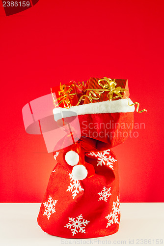 Image of Christmas presents in the bag against red background