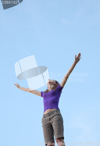 Image of Young woman sitting with raised hand