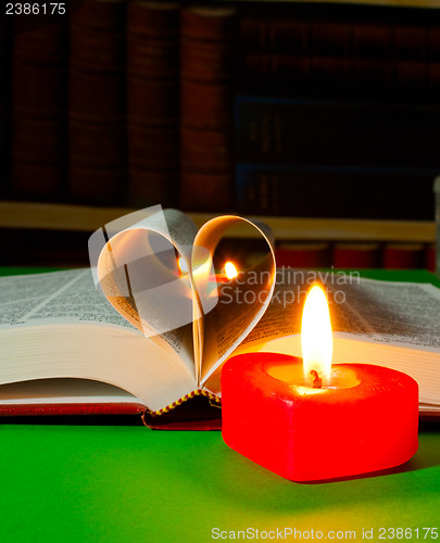 Image of Open book with burning candle