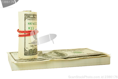 Image of Roll of US dollars tied up with rubber on the stack of bills