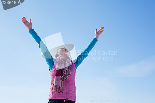 Image of Teen girl staying with raised hands