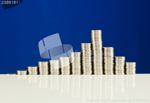 Image of Coins stacked in bars against blue background