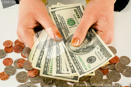 Image of Female's hands with 100 US dollar bills