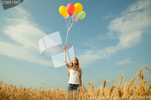 Image of Teen girl at a wheat field with balloons