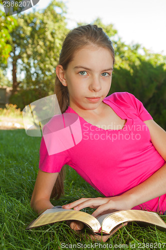 Image of Teen girl reading the Bible outdoors