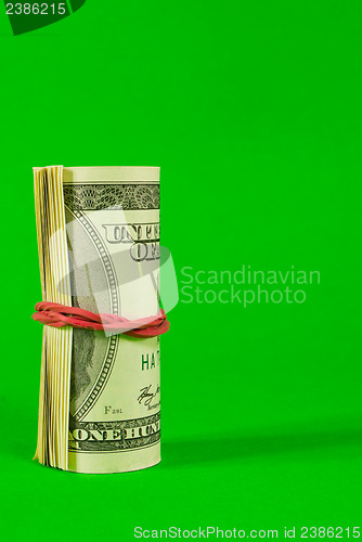 Image of Roll of US dollars tied up with rubber
