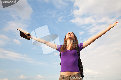 Image of Young woman staying with raised hands