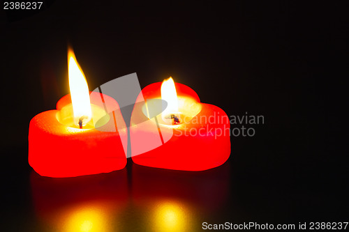 Image of Two heart shaped burning candles