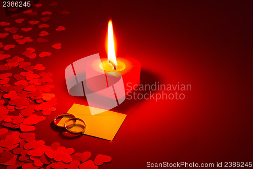 Image of Two rings and a blank card with burning candle