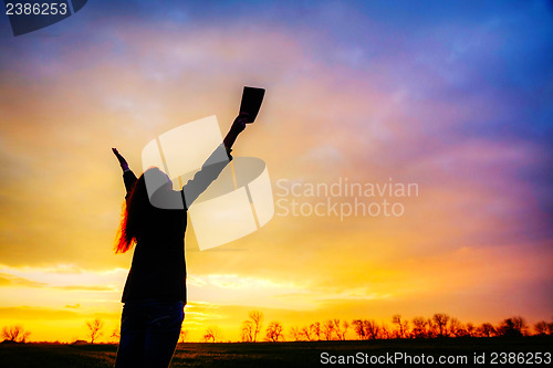 Image of Woman staying with raised hands