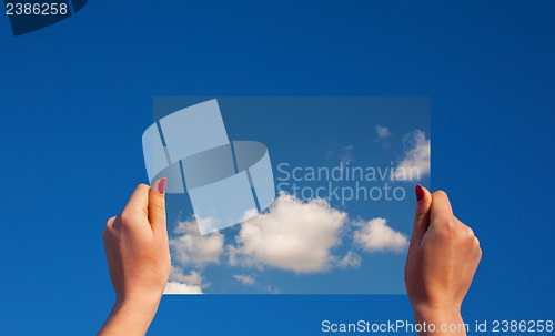 Image of Hands holding a frame with clouds