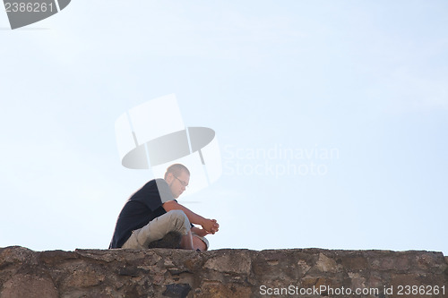 Image of Young man sittting outdoors