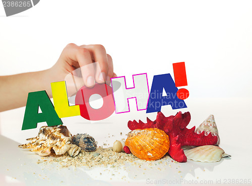 Image of Female's hand holding colorful word 'Aloha'