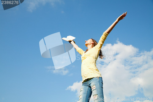 Image of Young woman staying with raised hands