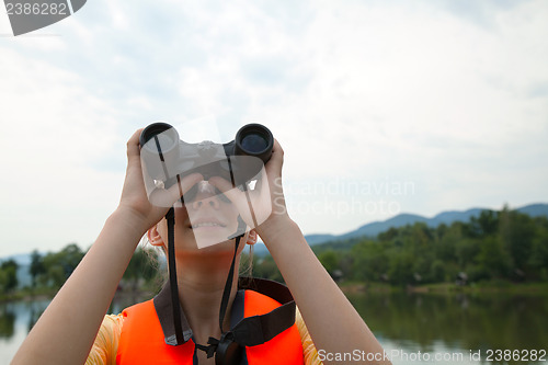 Image of Young woman looking through binoculars