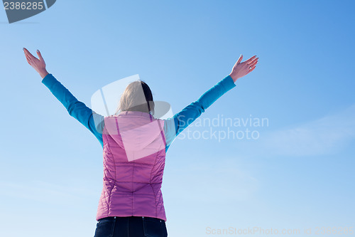 Image of Teen girl staying with raised hands