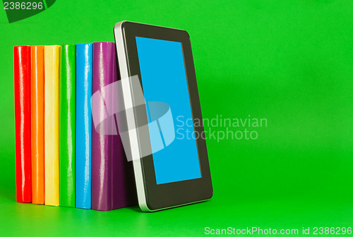 Image of Row of colorful books and tablet PC