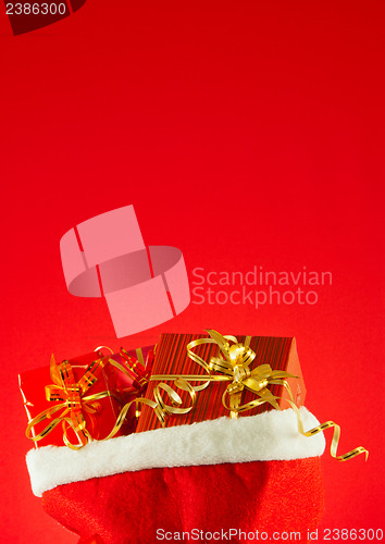 Image of Christmas presents in the bag against red background