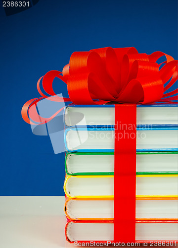 Image of Stack of colorful books tied up with red ribbon