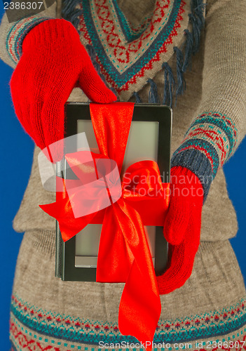 Image of Girl holds electronic book reader with red gloves