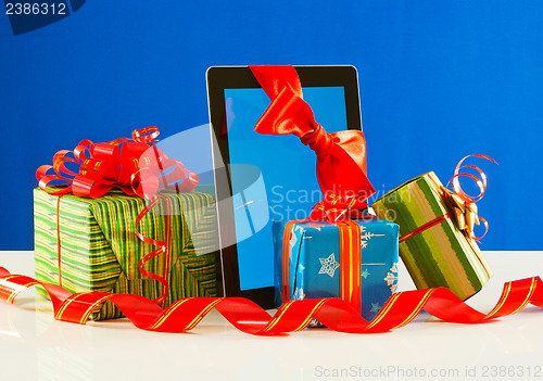 Image of Presents with a tablet pc against blue background