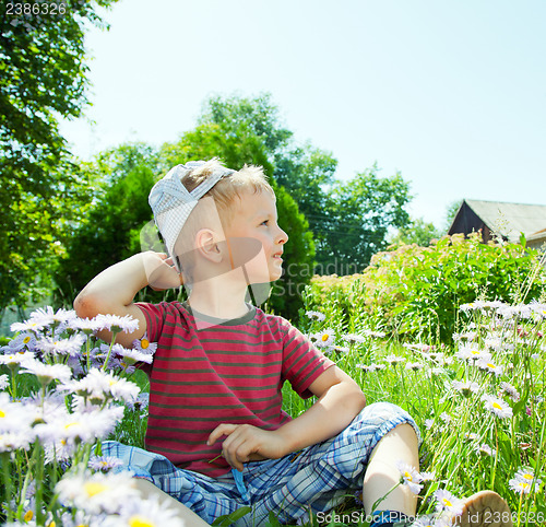Image of Small boy sitting on the grass